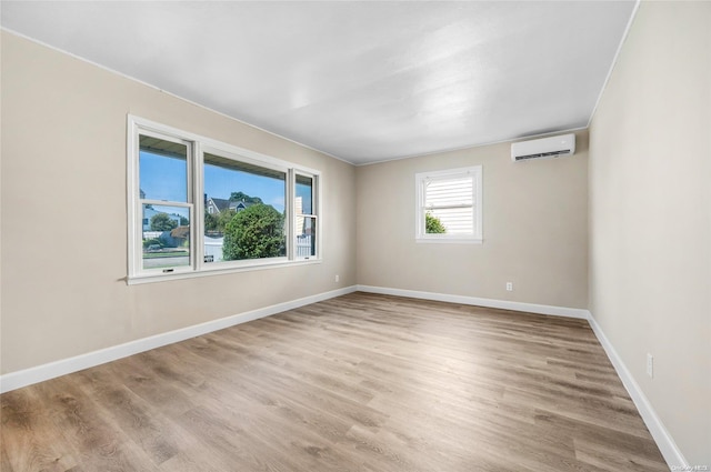 unfurnished room with light wood-type flooring and a wall mounted AC