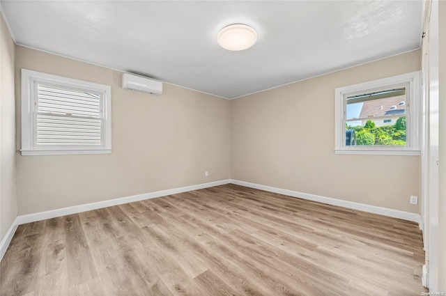 unfurnished room featuring a wall mounted air conditioner and light wood-type flooring