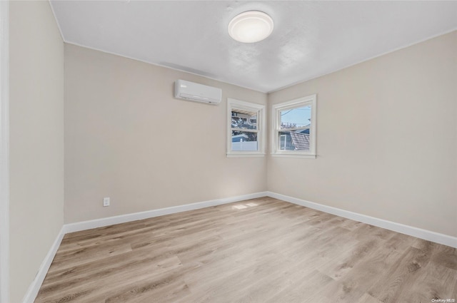 spare room with light hardwood / wood-style floors and a wall mounted AC