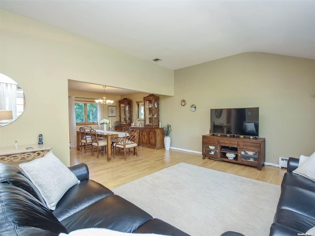 living room featuring a chandelier, light wood-type flooring, a baseboard radiator, and vaulted ceiling