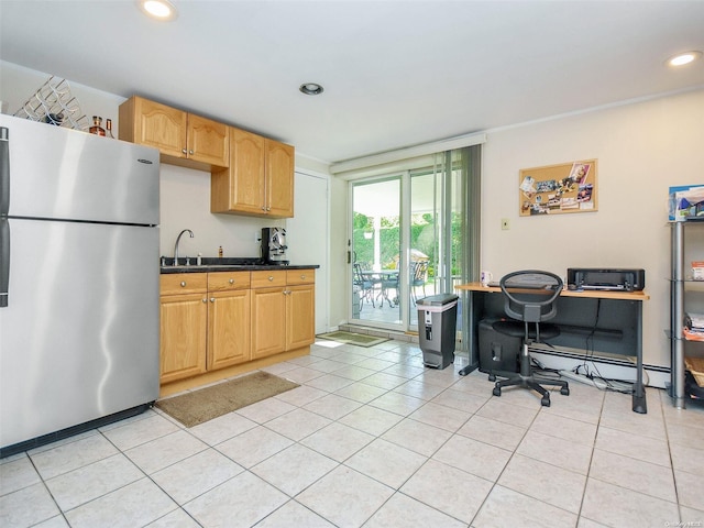 kitchen featuring light tile patterned floors, a baseboard radiator, stainless steel refrigerator, and sink