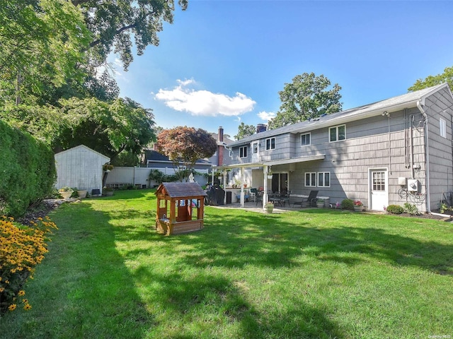 back of property with a patio area, a storage shed, and a yard