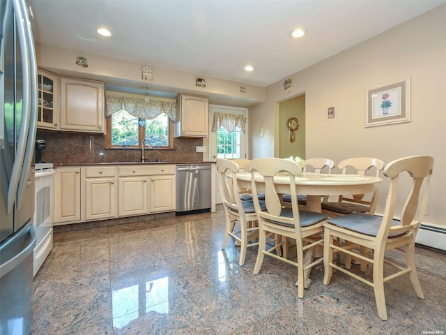 kitchen with backsplash, sink, cream cabinets, and appliances with stainless steel finishes