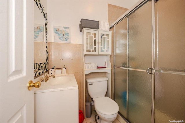 bathroom featuring walk in shower, vanity, tile walls, tile patterned flooring, and toilet