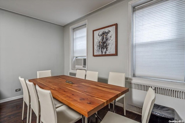 dining room with radiator heating unit, dark hardwood / wood-style floors, and cooling unit