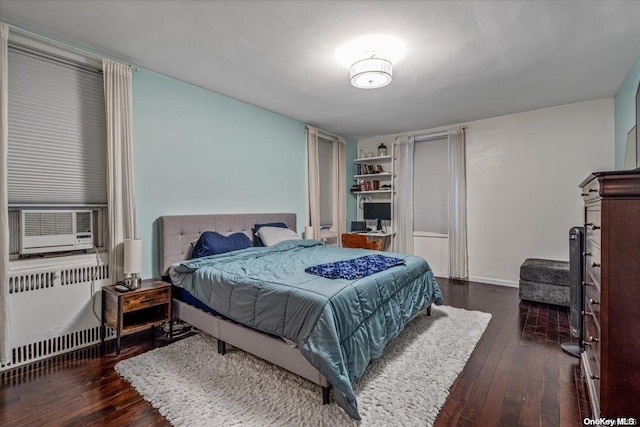 bedroom with radiator heating unit, cooling unit, and dark hardwood / wood-style floors