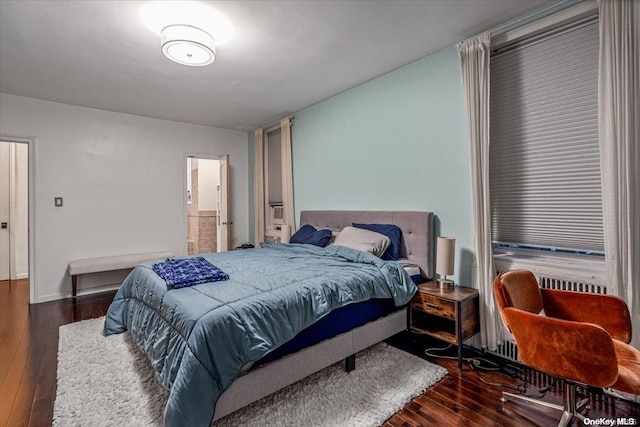 bedroom featuring dark hardwood / wood-style floors and ensuite bath