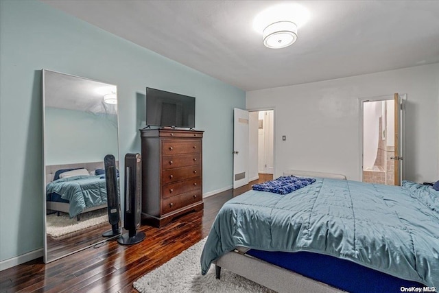 bedroom with dark hardwood / wood-style floors and connected bathroom