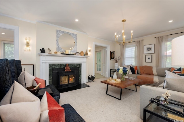 living room with a high end fireplace, crown molding, and a notable chandelier