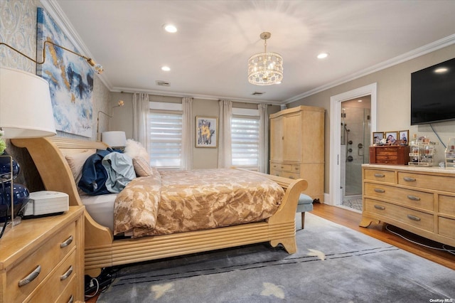 bedroom featuring hardwood / wood-style flooring, ensuite bathroom, crown molding, and an inviting chandelier