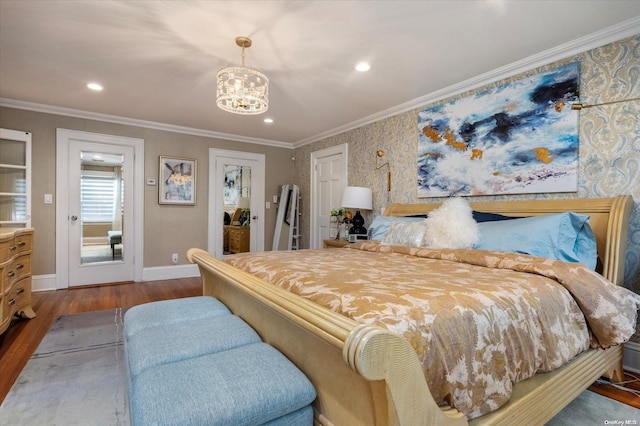 bedroom featuring hardwood / wood-style floors, crown molding, and a notable chandelier