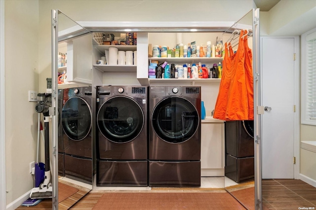 laundry room with washing machine and dryer and light hardwood / wood-style floors