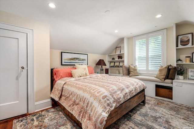 bedroom with dark wood-type flooring and lofted ceiling