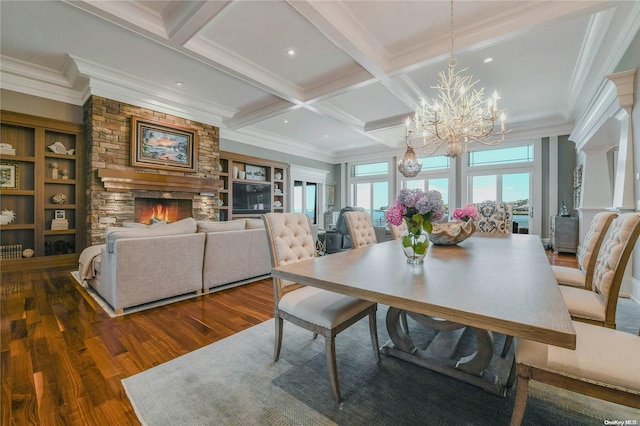 dining area featuring coffered ceiling, dark wood-type flooring, beamed ceiling, a stone fireplace, and a notable chandelier