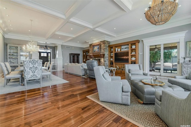 living area with coffered ceiling, dark wood-type flooring, an inviting chandelier, a fireplace, and beam ceiling