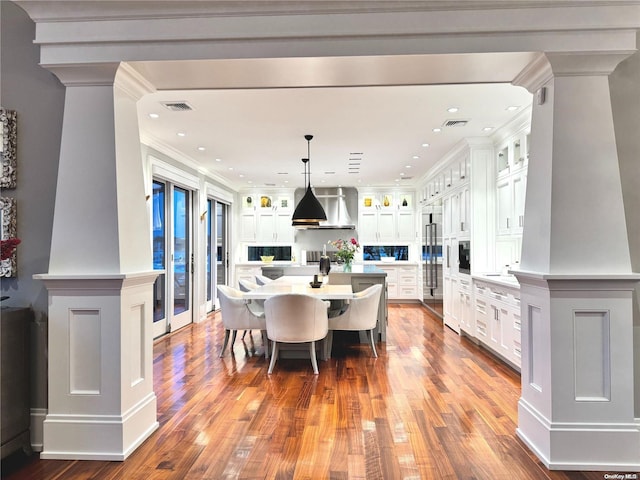 dining space with ornate columns, dark wood finished floors, visible vents, and crown molding