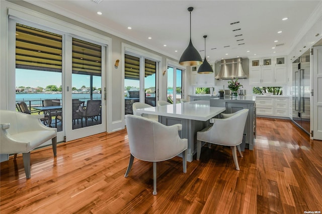 dining space with recessed lighting, wood finished floors, and crown molding