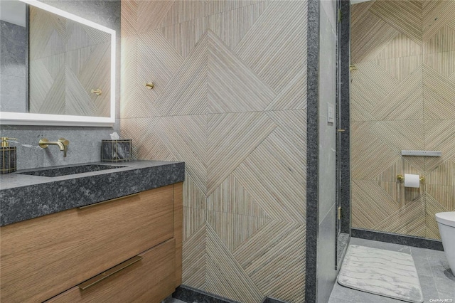 bathroom with tile walls, toilet, and vanity