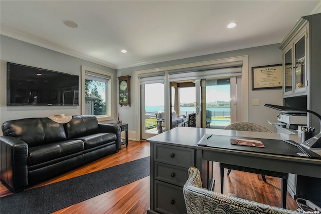 interior space featuring recessed lighting, a water view, wood finished floors, baseboards, and crown molding