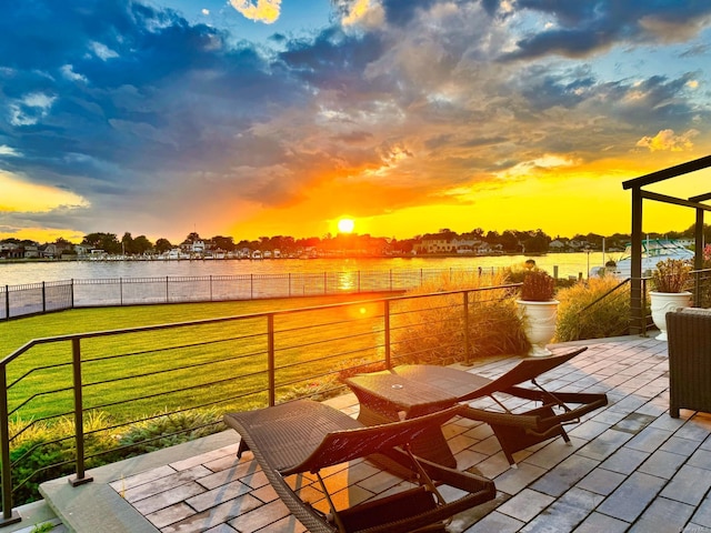 view of patio / terrace with a water view and fence