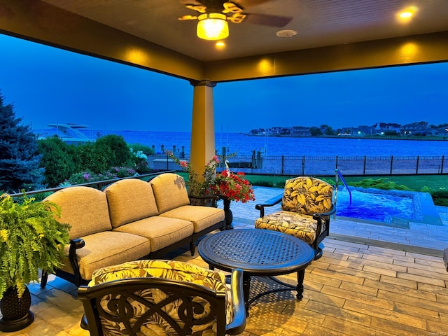 view of patio / terrace featuring ceiling fan, outdoor lounge area, a water view, and fence