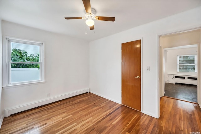 empty room with ceiling fan, hardwood / wood-style floors, and a baseboard radiator