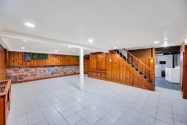 basement with wood walls and washer / dryer