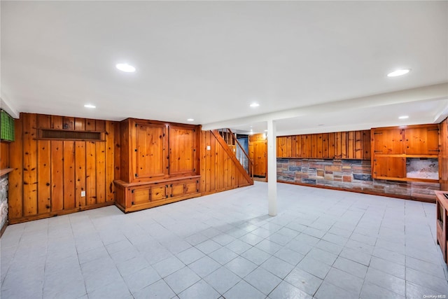 basement featuring wooden walls