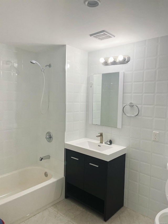 full bathroom with tiled shower / bath combo, vanity, tile walls, and toilet