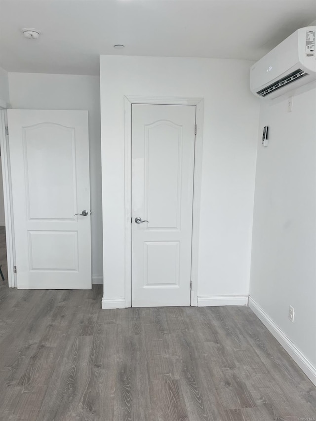 interior space featuring hardwood / wood-style flooring and a wall unit AC