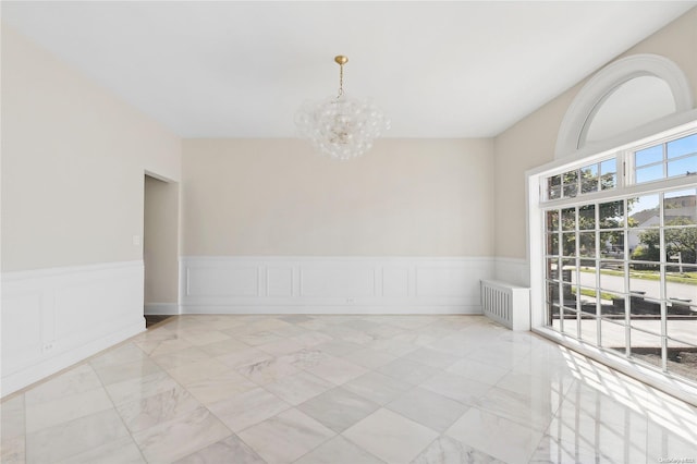65 W Beech St, Long Beach, NY 11561 - empty room with a chandelier, light marble finish flooring, wainscoting, a decorative wall, and radiator heating unit