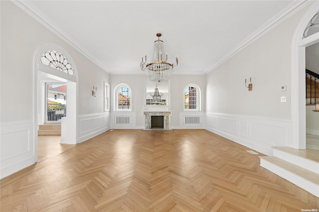 unfurnished living room featuring light parquet flooring, plenty of natural light, and ornamental molding