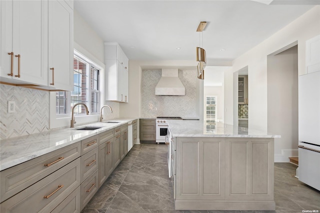 kitchen featuring light stone countertops, premium range hood, pendant lighting, decorative backsplash, and high end range