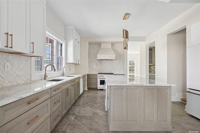 65 W Beech St, Long Beach, NY 11561 - kitchen featuring wall chimney range hood, range with gas cooktop, a sink, a kitchen island, and tasteful backsplash