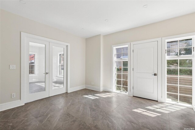 65 W Beech St, Long Beach, NY 11561 - unfurnished room with french doors, plenty of natural light, marble finish floors, and baseboards