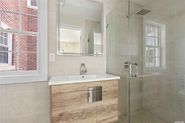 bathroom featuring a wealth of natural light, vanity, and tile walls