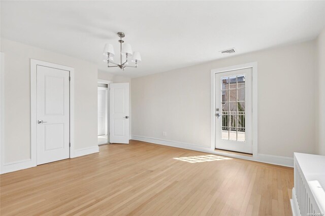 65 W Beech St, Long Beach, NY 11561 - unfurnished dining area featuring light wood-style floors, a chandelier, and baseboards