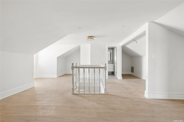 bonus room with light hardwood / wood-style floors and vaulted ceiling