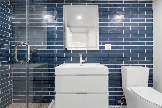 bathroom with toilet, vanity, tile walls, and walk in shower