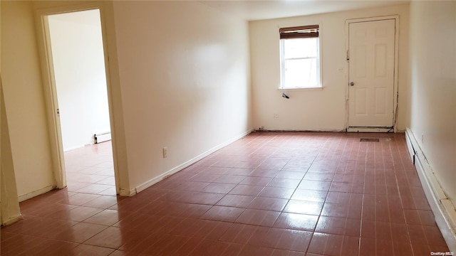 spare room with tile patterned flooring and a baseboard radiator