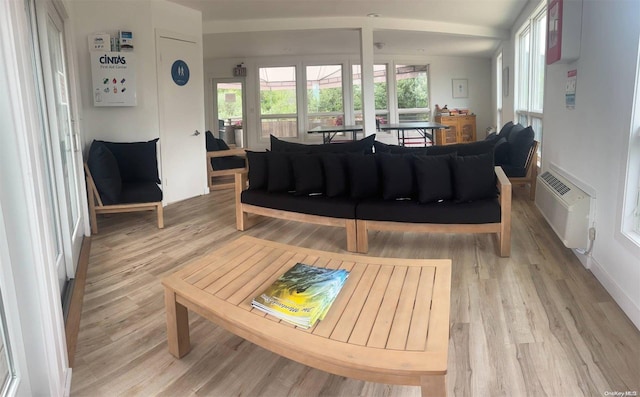 living room with light hardwood / wood-style floors, an AC wall unit, and vaulted ceiling