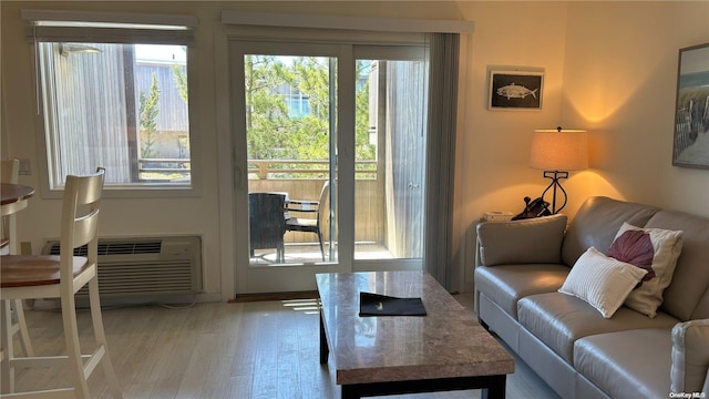 doorway to outside with an AC wall unit and hardwood / wood-style floors