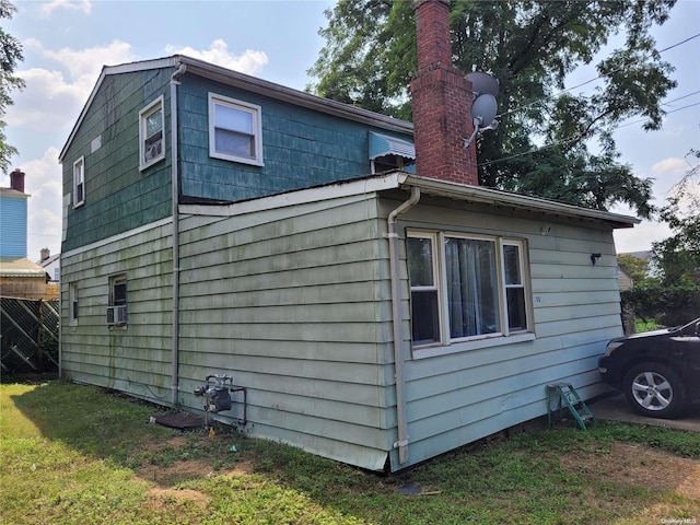 view of home's exterior featuring cooling unit and a lawn