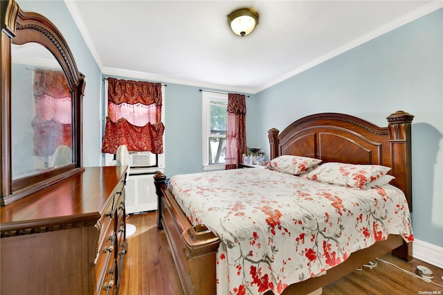 bedroom with radiator, crown molding, and dark hardwood / wood-style flooring