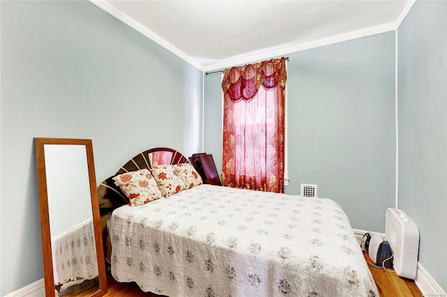 bedroom with hardwood / wood-style flooring and crown molding