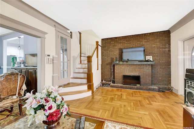 living room featuring parquet flooring, a fireplace, and brick wall