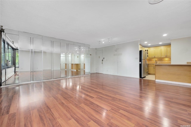 unfurnished living room with light hardwood / wood-style floors and a textured ceiling