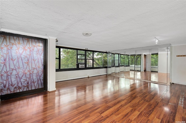 unfurnished room with a textured ceiling and hardwood / wood-style flooring