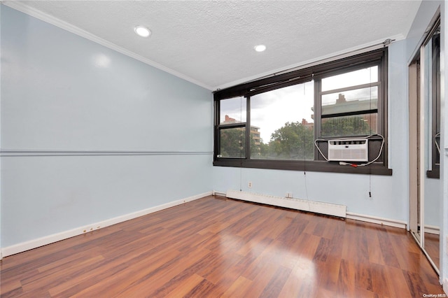 empty room with wood-type flooring, a textured ceiling, a baseboard radiator, and cooling unit