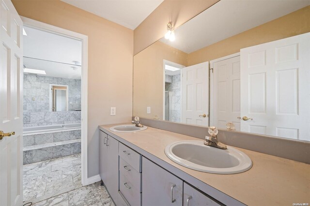 bathroom featuring vanity and a relaxing tiled tub